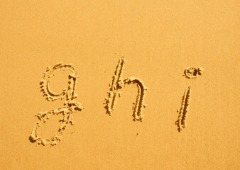 alphabet letters g h i handwritten in sand