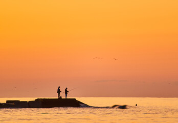 Fisherman on sunrise on the pier