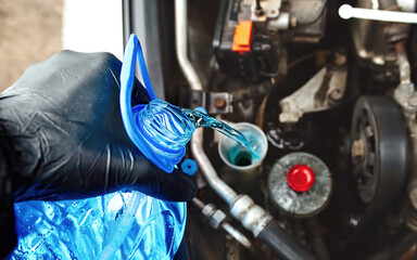Pouring antifreeze liquid screen wash. Filling windscreen water tank with winter washer fluid...