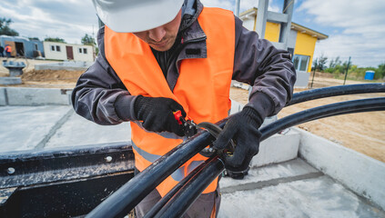 Two electrician builder workers installing high-voltage cable