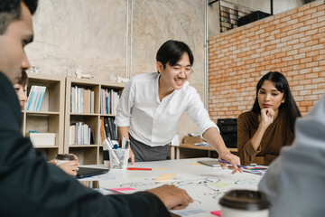 Multiracial group of young creative people in casual wear meeting brainstorming ideas about new paperwork project colleagues working together planning success strategy enjoy teamwork in small office