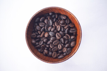 Fototapeta premium coffee beans in a wooden bowl on a white table