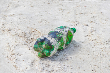 Plastic bottle stranded washed up garbage pollution on beach Brazil.