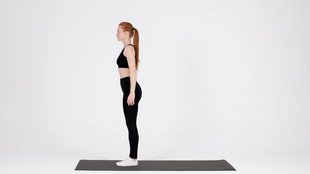 Sporty young woman making back lunges exercise in studio