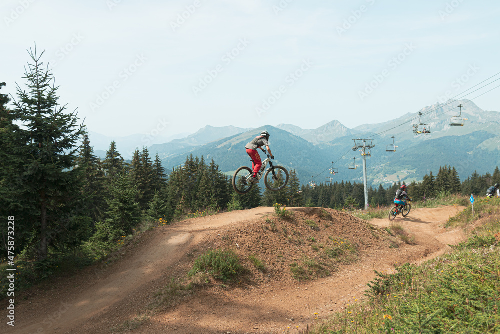 Wall mural Red biker Jumping over a table in Super Morzine bike park, Portes du Soleil, Alps, France