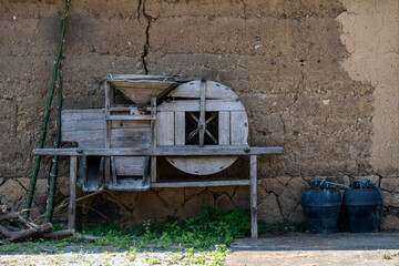 Fototapeta na wymiar The paddy windmill in the countryside, the farm implements by the mud wall