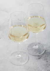 Two glasses of white homemade summer refreshing wine on light background.