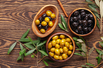 Black and green Olives, olive tree branch and ciabatta bread on dark wooden table. Top view. Flat lay