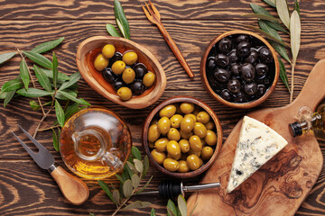 Black and green Olives, olive tree branch and ciabatta bread on dark wooden table. Top view. Flat lay