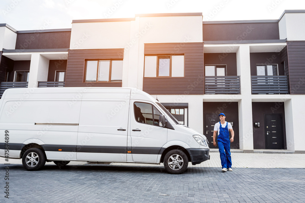 Wall mural two removal company workers unloading boxes from minibus into new home