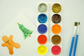 Watercolor paints and brushes for painting. Christmas creativity concept. Top view, copy space, flat lay.	