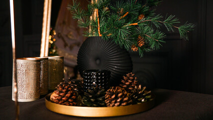 Pine cones decor for Christmas table. Christmas table decoration with candles. Dark background