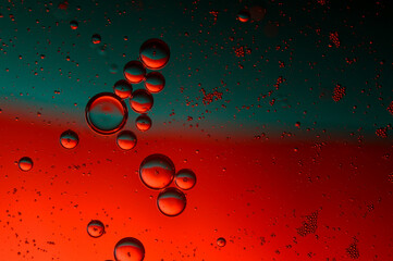 abstract background. drops of oil on water, red and green color. macro