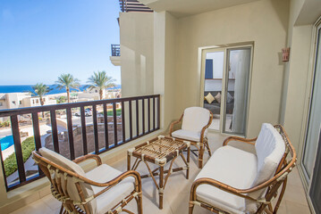 Terrace balcony with chairs in tropical luxury apartment resort - obrazy, fototapety, plakaty