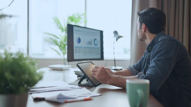 Casual relax working at home,male caucasian wear casual shirt checking business finance chart with desktop on dining table,male adult relax working at living room at home