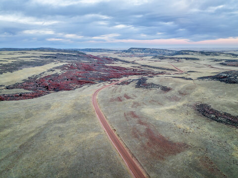 dusk over foothills of Rocky Mountains in northern Colorado with a dirt ranch road, aerial view of fall or winter scenery