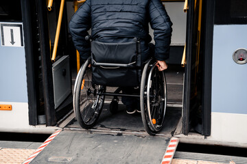Person with a physical disability enters public transport with an accessible ramp.