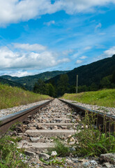 Der Weg ins Irgendwo. Perspektivischer Blick von Bahnschienen, die scheinbar in einen Wald führen.