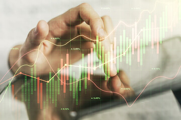 Abstract creative financial graph with finger clicks on a digital tablet on background, financial and trading concept. Multiexposure