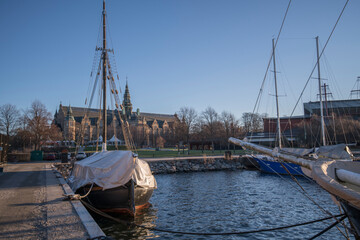Old preserved sail ship an a gothic old museum building in the island Djurgården a sunny winter day in Stockholm