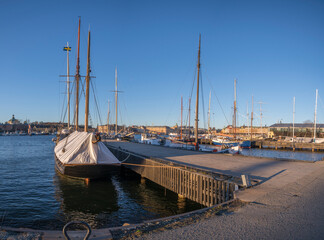 Fototapeta na wymiar View with winter closed old sailing boats at the bay Ladugårdsviken a sunny winter day in Stockholm