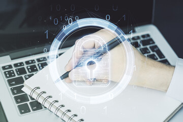 Creative lock sketch with chip hologram and hand writing in notepad on background with laptop,...