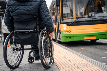 Person with a physical disability waiting for city transport with an accessible ramp.