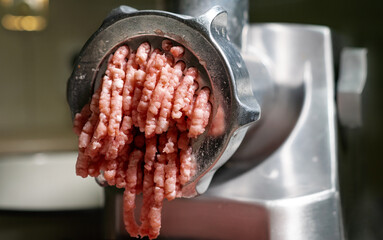 Cooking minced meat in an electric meat grinder from fresh meat at home.