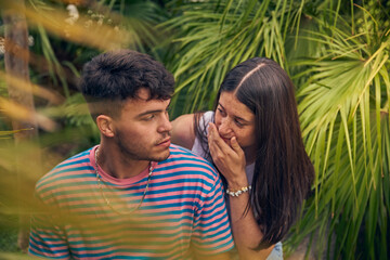 young couple looking a laptop and talking with her friends