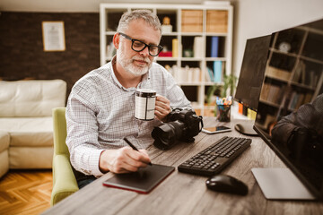 Photographer with beard, while working in his office at home.