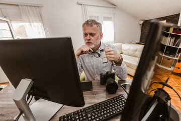 Photographer with beard, while working in his office at home.