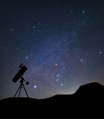 Silhouette of the telescope against the background of the winter Milky Way and the constellation...