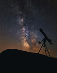 Silhouette of the telescope against the background of the night sky. Astronomical observations of the Milky Way. 