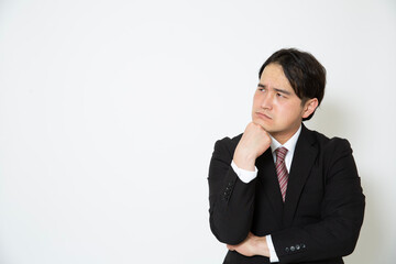 考えるスーツの男性