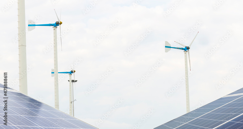 Wall mural solar panels and wind turbines under sky and clouds horizon.