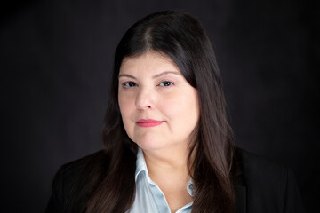 Fototapeta premium Professional lady poses for a headshot. She is elegant and look straight to the camera