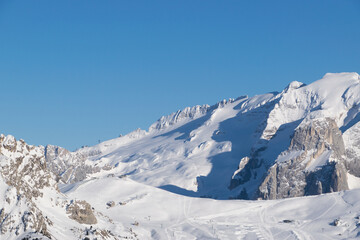 Fototapeta na wymiar Panorama sul Ghiacciaio della Marmolada in inverno, paesaggio innevato verso le vette e le piste da sci di Canazei in Trentino
