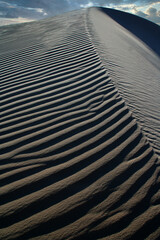 Beautiful dune sand textures as wind blows the sand across with a beautiful blue sky