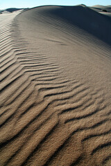 Beautiful dune sand textures as wind blows the sand across with a beautiful blue sky