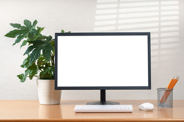 Front view of simple workspace with modern computer and office supplies. Blank screen for your text...