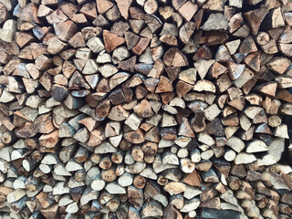 Firewood background. Wooden texture. Natural abstract pattern.  Tree trunks from front view stacked on top of each other.