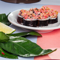 japanese rolls with a cap on a plate on a pink and blue background