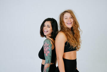 Two young women posing over white background.