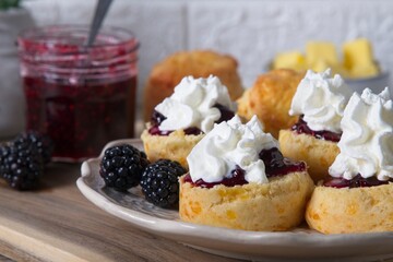 Fresh scones with homemade blackberry jam, cream and fresh blackberries