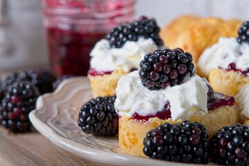 Close-up of scones with homemade blackberry jam, cream and fresh blackberries