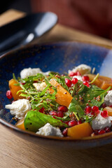 Delicious persimmon salad with pomegranate and arugula