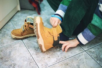 Dziecko przygotowujące się do wyjścia z domu i zakładające buty