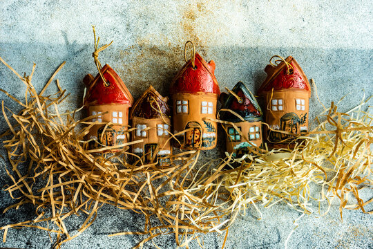 Festive Christmas arrangement of clay house ornaments and straw