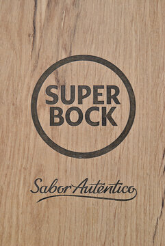 Marca, logótipo de cerveja portuguesa Super Bock, gravado numa madeira - queimado - gravação a laser - relevo - slogan, sabor autêntico - bebida  