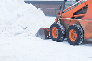 Snowfall.There is a lot of snow in the city.Snow removal by a special tractor.